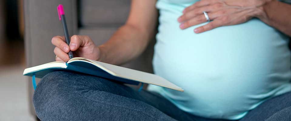 Woman taking notes on the risks of elective c-sections.