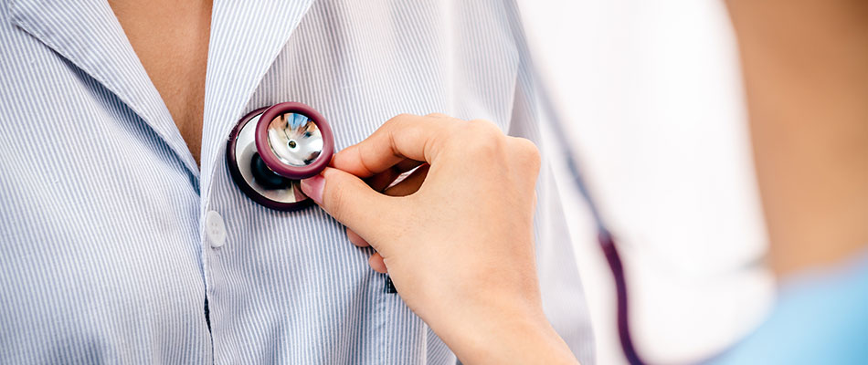 A doctor at a Centers of Excellence-approved facility listens to her patient's heartbeat with a stethoscope.