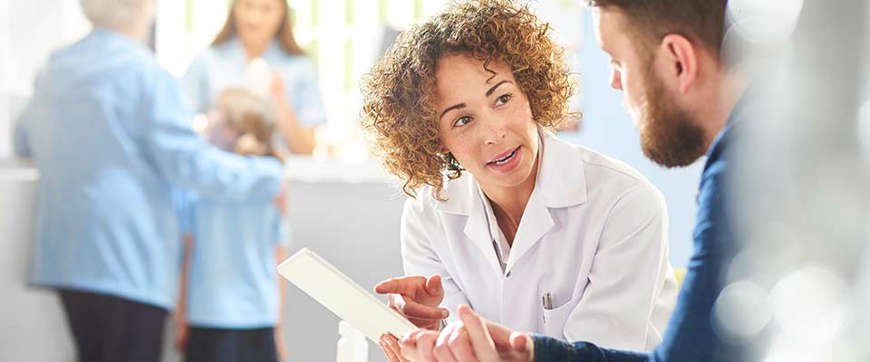 A female doctor looks at her patient while discussing post-surgery discharge orders.