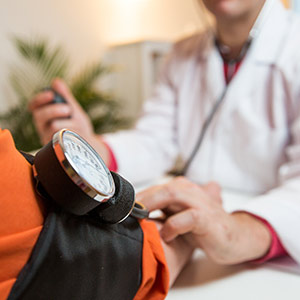 A doctor measures his patient's blood pressure, as part of a company's biometric screening initiative.