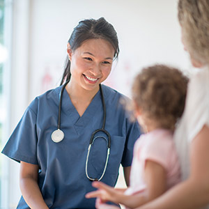 Healthcare provider demonstrates attentive bedside manner to mother and child.