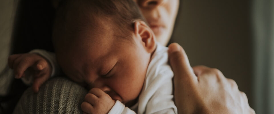 Mother holding head of newborn son