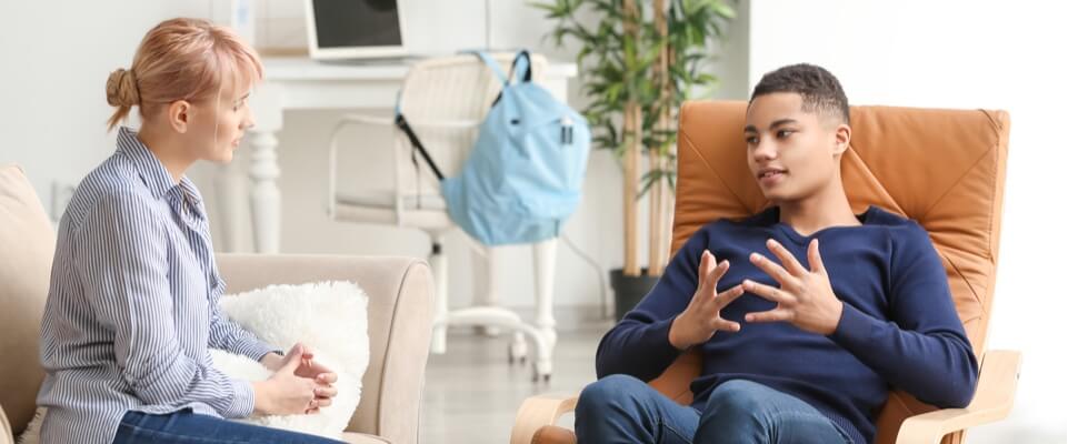 Therapist talking to a young man.